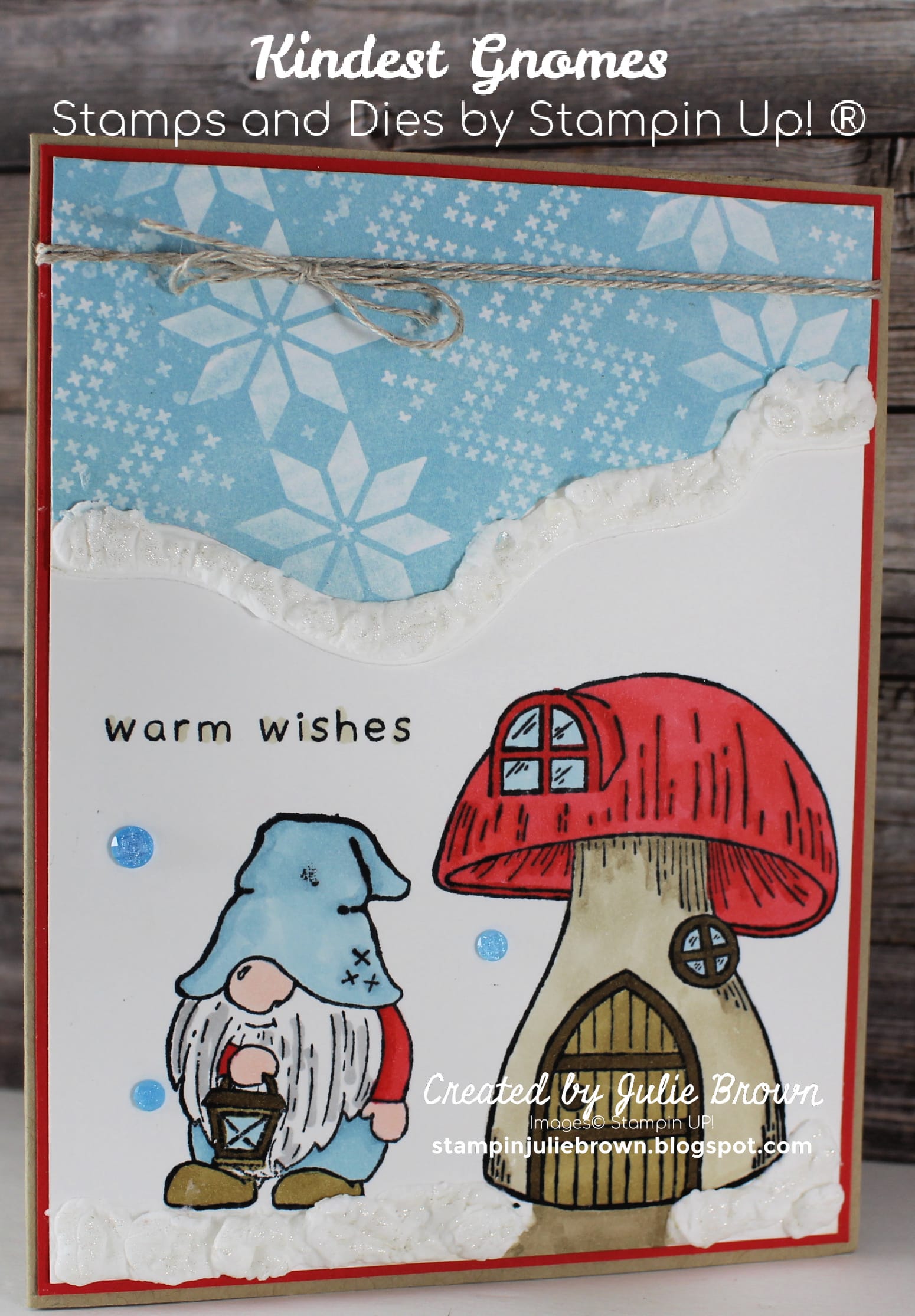 Card designed with the Kindest Gnomes Stamp set by Stampin Up® Showing how it looks when colored in with Blends using the Mushroom house on bottom right of Basic White card front and a Gnome holding a lantern to the left of the Mushroom.  Gnome and Mushroom have been colored in using Real Red, Crumb Cake and Soft Suede for the Mushroom and Balmy Blue, Soft Suede and Real Red for the Gnome.  Stamped section layered onto Designer Series Paper with snowflake designs.